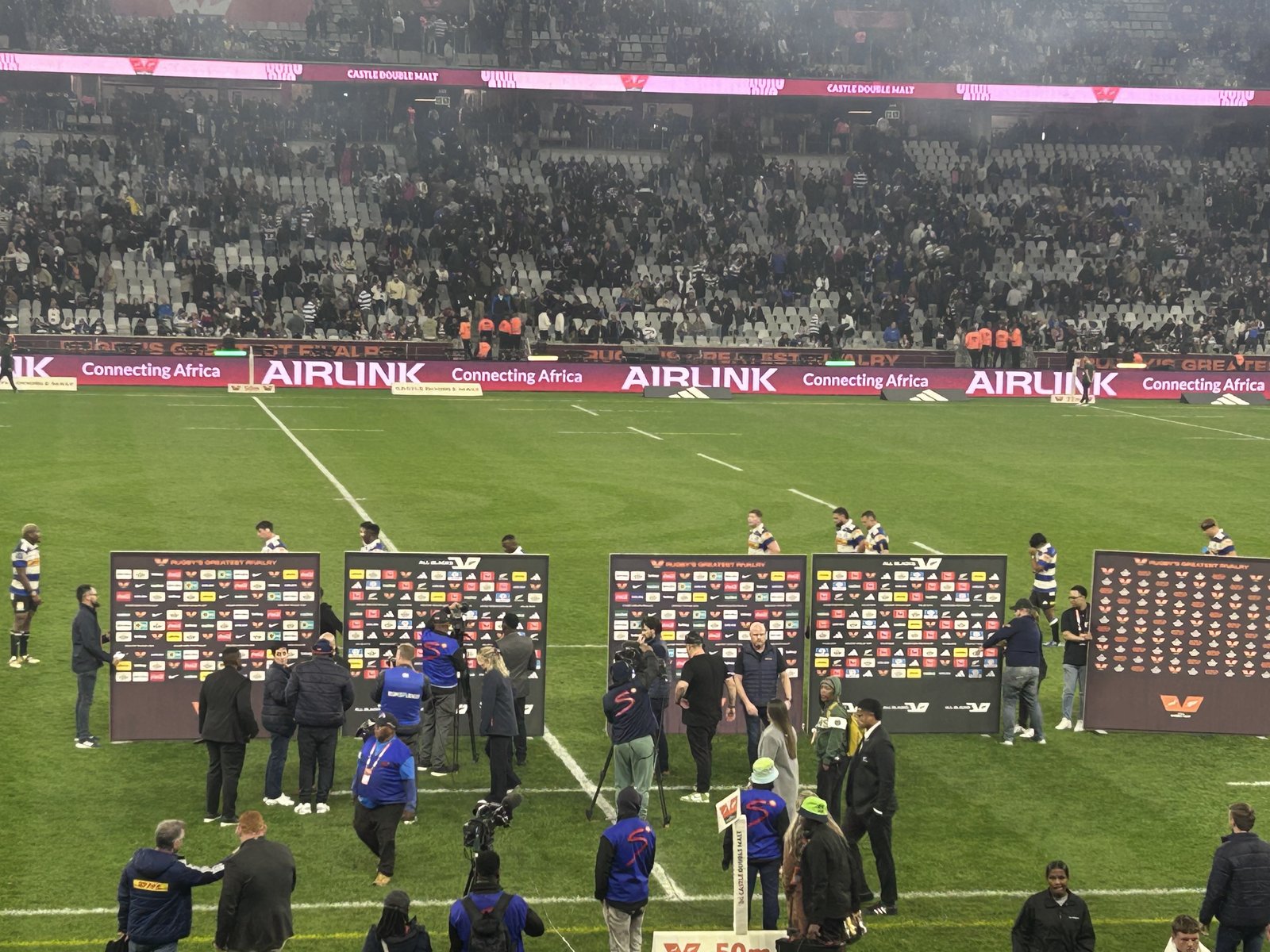 Spelers en media op die veld by die DHL-stadion in Kaapstad ná die All Blacks se 38-21 oorwinning oor die DHL Stormers