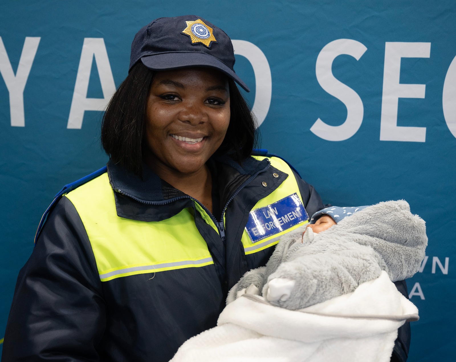 Cape Town Law Enforcement officer Zibula Sitemele holding baby Mahier Luyt